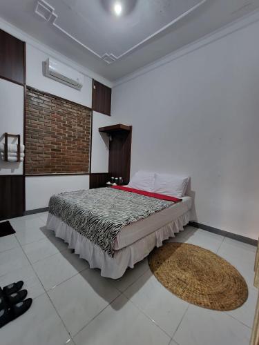 a bedroom with a bed and a rug on the floor at Domore Lifestyle in Jetis