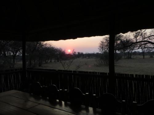 a view of a sunset from a screened in porch at Isilwane Bush Camp in Pretoria