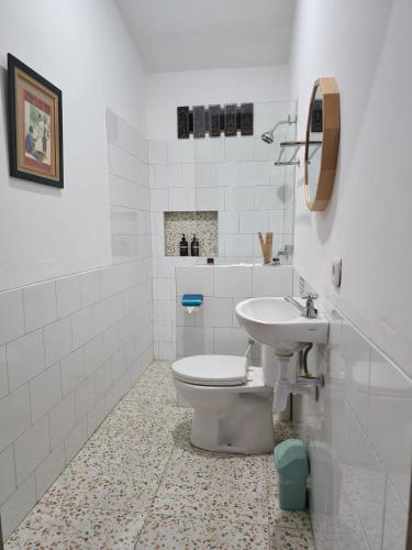 a white bathroom with a toilet and a sink at Domore Lifestyle in Jetis