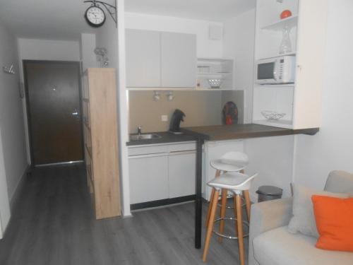 - une cuisine avec un comptoir, un évier et un canapé dans l'établissement Appartement 2 personnes cures ski luchon, à Luchon