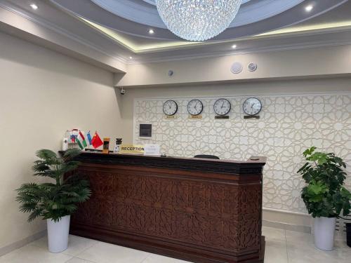 a reception desk in a lobby with clocks on the wall at Beksaroy in Samarkand