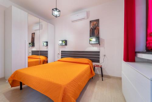 a bedroom with two beds with orange sheets at Casa Violante in Alghero