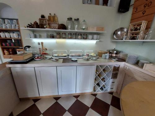 a kitchen with white cabinets and a checkered floor at Hotel Kapelle Bed & Breakfast in Bad Liebenstein