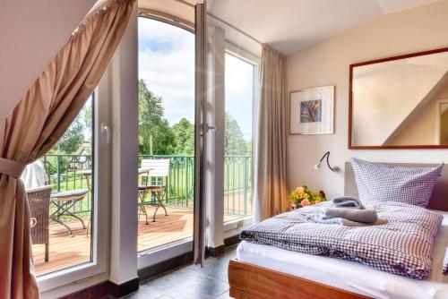 ein Schlafzimmer mit Bett und Balkon in der Unterkunft Kapitäns Hus Ferienhaus Avantgarde in Putbus