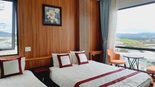 a hotel room with two beds and a large window at NEST House in Ấp Kim Thạch