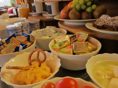 una mesa cubierta con tazones de comida y fruta en Waldgasthof Pension Baodwirt, en Stephanskirchen