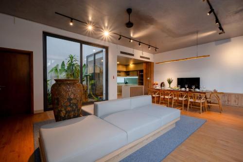 ダナンにあるSila Prana Villa - Luxury Private 8BRs Pool Villa Da Nang Beachのリビングルーム(白いソファ付)、ダイニングルーム