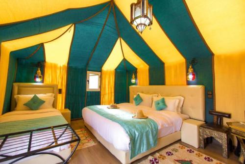 Ένα ή περισσότερα κρεβάτια σε δωμάτιο στο Merzouga Desert Campsite &Activities