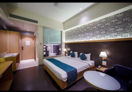 a bedroom with a large bed and a bathroom at Gopalas Residency Bhumi World Bhiwandi in Bhiwandi