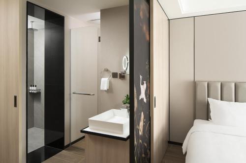 a bathroom with a sink and a bed at Modena by Fraser Vinh Yen in Yen