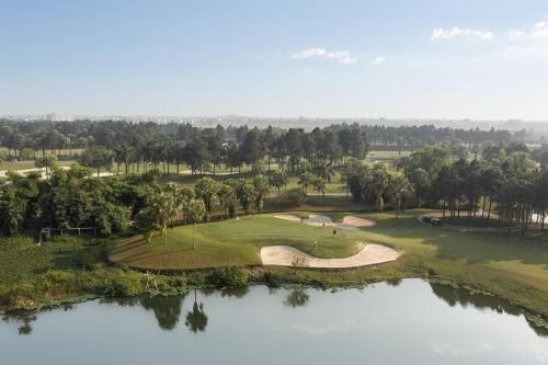 an aerial view of a golf course with a pond at Modena by Fraser Vinh Yen in Yen