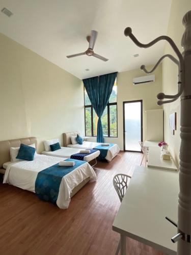 a bedroom with two beds and a table at Forest Lodge, Radiant Janda Baik in Bentong