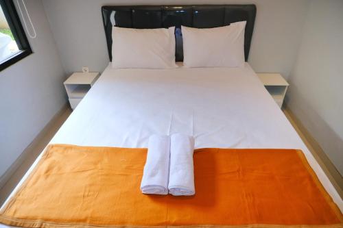 a bedroom with a bed with two towels on it at Djuragan Kamar Balawan in Bareng
