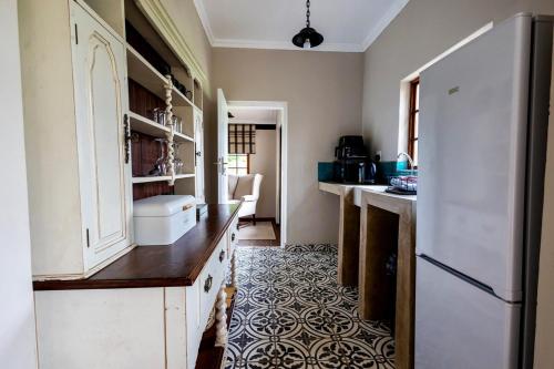 a kitchen with a white refrigerator and a kitchen floor at Ebernburg Cottage in Nottingham Road