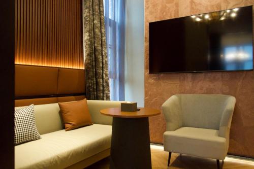 a living room with a couch and a chair and a tv at Shengjing Hotel Beijing Temple of Heaven East Gate Subway Station Branch in Beijing