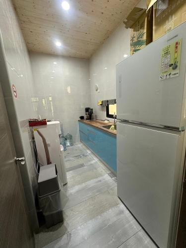 a kitchen with a white refrigerator and a sink at One third of an acre B&B in Magong