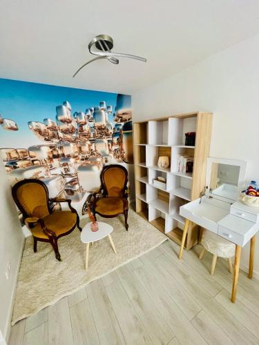 - un salon avec des chaises, une table et un lustre dans l'établissement Oasis Spa près de Disney, à Nanteuil-lès-Meaux