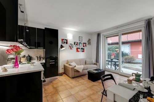 Una cocina y una sala de estar con un sofá y una mesa. en Residence Due Laghi - Happy Rentals, en Ispra