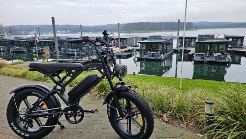 a bike parked on a sidewalk near a marina at Houseboats Mookerplas in Middelaar