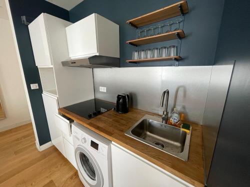 une petite cuisine avec un évier et une machine à laver dans l'établissement Quiet apartment - Close to metro Saint Michel, à Toulouse