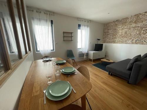 un salon avec une table en bois et un canapé dans l'établissement Quiet apartment - Close to metro Saint Michel, à Toulouse