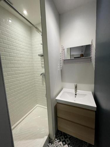 une salle de bain blanche avec un lavabo et une douche dans l'établissement Quiet apartment - Close to metro Saint Michel, à Toulouse