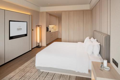 a bedroom with a white bed and a flat screen tv at Modena by Fraser Vinh Yen in Yen