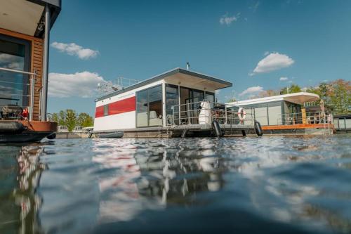 a house on a boat on a body of water at Floatinghouses Zehdenick in Zehdenick