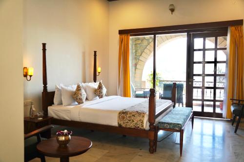 a bedroom with a bed and a large window at Saket LOAK in Udaipur