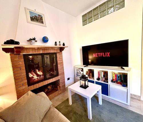 a living room with a fireplace and a flat screen tv at Romantica casa con camino Centro storico Vasanello in Vasanello