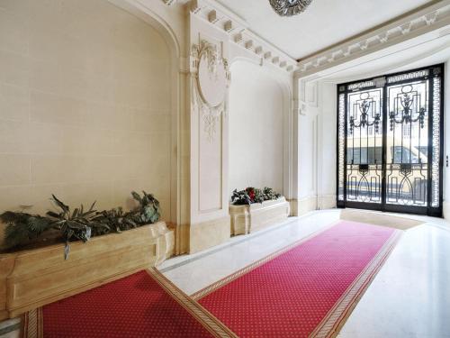 an empty hallway with a red rug and a window at Cosy & bright studio - 2P - Ternes in Paris