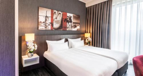 a bedroom with a large white bed in a room at PLAZA Premium Grand Winston in Rijswijk