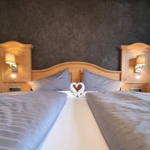 a bedroom with two beds with a heart shaped towel at B&B Gästehaus Alpenblick in Lermoos