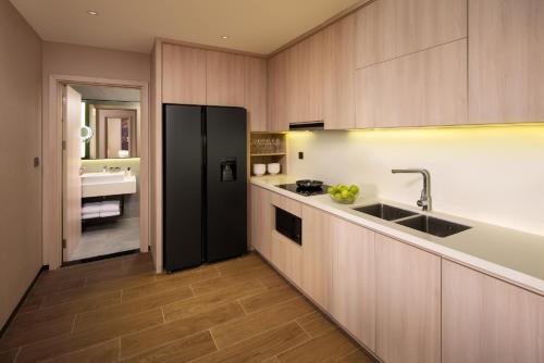 a kitchen with a sink and a black refrigerator at Modena by Fraser Vinh Yen in Yen