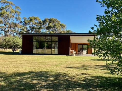 a modern house with a large grassy yard at Salt House Brand New Bayside Accommodation in Bream Creek
