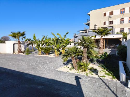 a row of palm trees in front of a building at VISTAMARE beach garden relax in San Leone