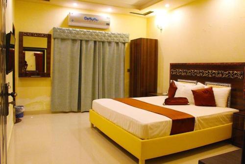 a bedroom with a large bed in a room at Hotel Day In in Lahore