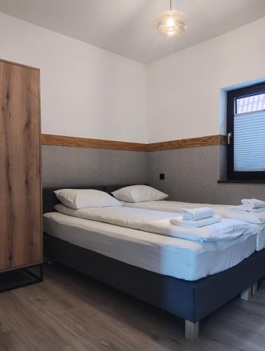 a bedroom with a large bed with white sheets at APART 558 Szczyrk, Ski&Bike, basen, blisko wyciągów i szlaków in Szczyrk