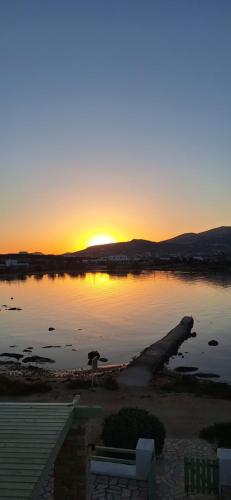 a sunset over a body of water with a dock at Mike'sPlace in Antiparos Town