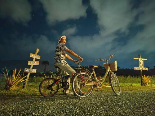 a man is riding a bike on a road at Cana Garden House 2 in Ban Khok