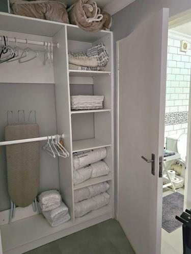 a closet with white towels and a door at Giraffe's Rest, Self Catering Studio Apartment in White River