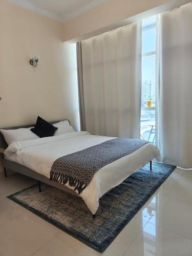 a bedroom with a large bed with a window at Studio in the heart of Sports City -great view & amenities! in Dubai