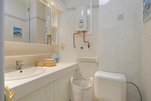 a bathroom with a sink and a toilet and a mirror at Atlantis 0102 in Sint-Idesbald