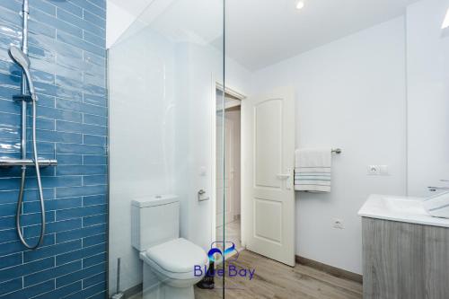 Un baño con inodoro y ducha de cristal. en Palm Beach Apartment, en La Herradura