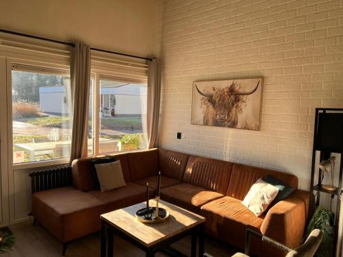 a living room with a couch and a bull painting on the wall at Huuske14 in Simpelveld