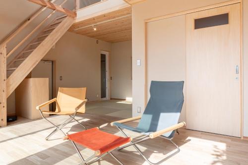 two chairs in a room with a staircase at 富津オフグリッドハウス - Futtsu Seaside Off-Grid House with Private Sauna in Futtsu