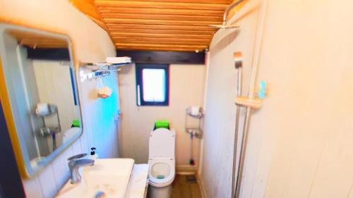 a bathroom with a toilet and a sink and a mirror at Đồi Mây Homestay Bảo Lộc in Bao Loc