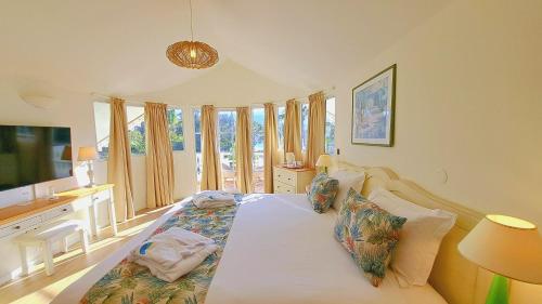 a bedroom with a bed with a desk and windows at Le Nautile Beachfront in Saint-Gilles les Bains