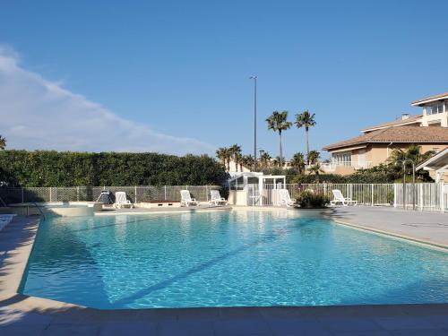 une piscine avec de l'eau bleue dans une cour dans l'établissement Cap HERMES, T2-3, 40m2, 4-5p, ,grande terrasse vu, à Fréjus