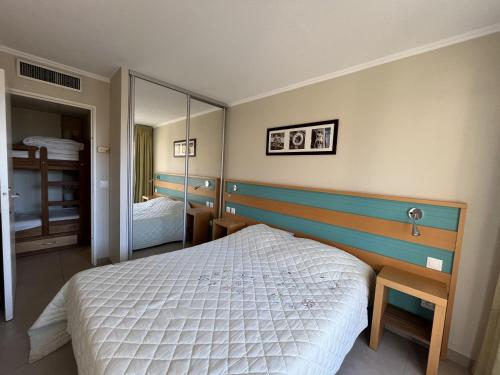 une chambre avec un lit et un grand miroir dans l'établissement Cap HERMES, T2-3, 40m2, 4-5p, ,grande terrasse vu, à Fréjus